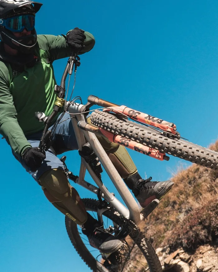Un ciclista de montaña desciende por un terreno rocoso, demostrando control y técnica.