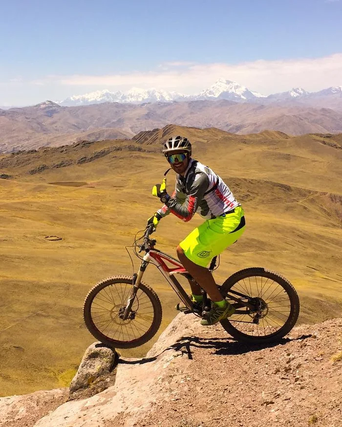 A mountain biking scene at higher elevation in Peru, with open views and rugged terrain in the Sacred Valley.