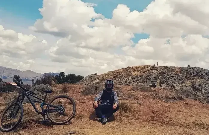En Mountain bike con restos históricos en Cusco, el terreno seco y pedregoso rodea al rider; en este caso, el lugar corresponde al Templo del Sol y la Luna.