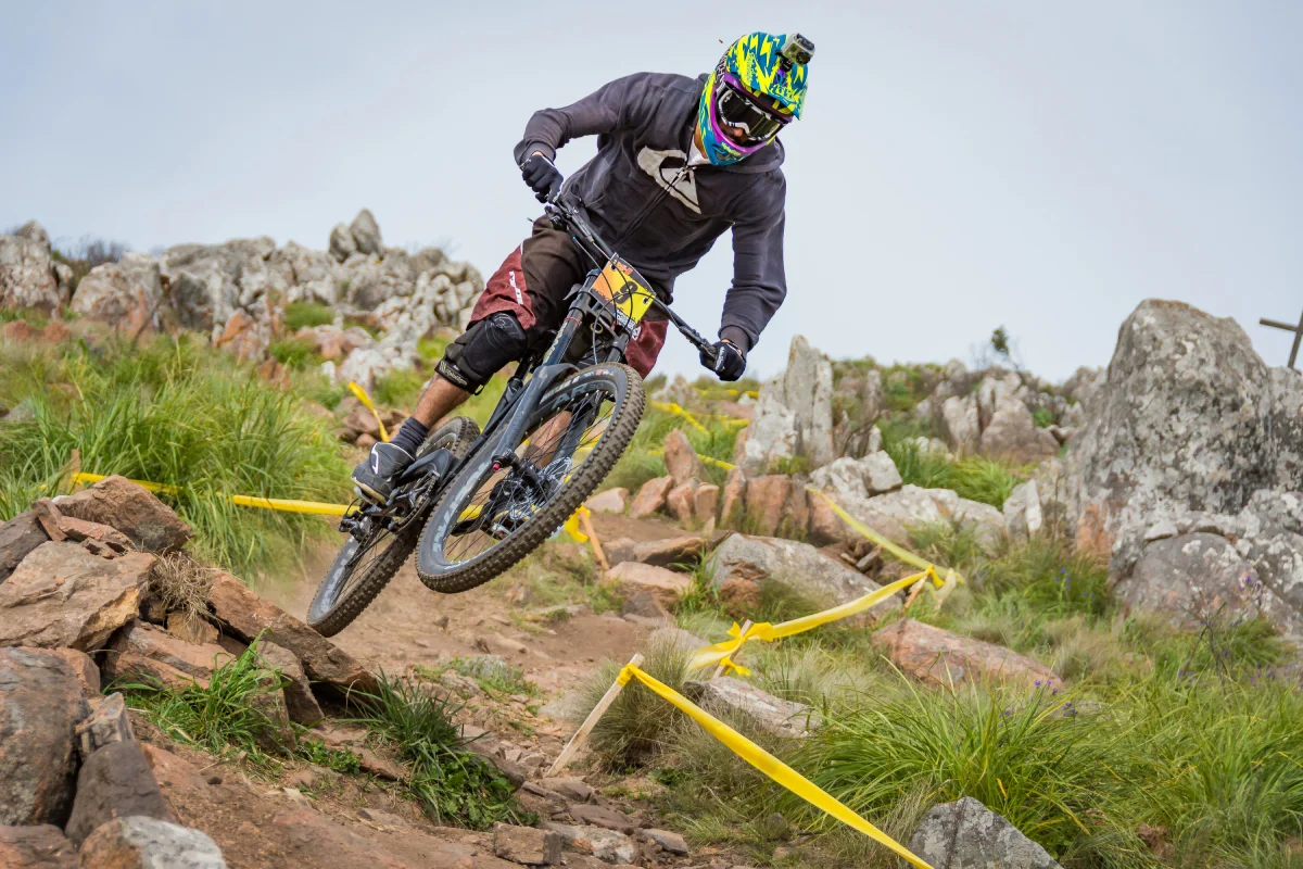 Ciclista de montaña en pleno salto sobre un sendero rocoso en Cusco, mostrando la intensidad y técnica del MTB.