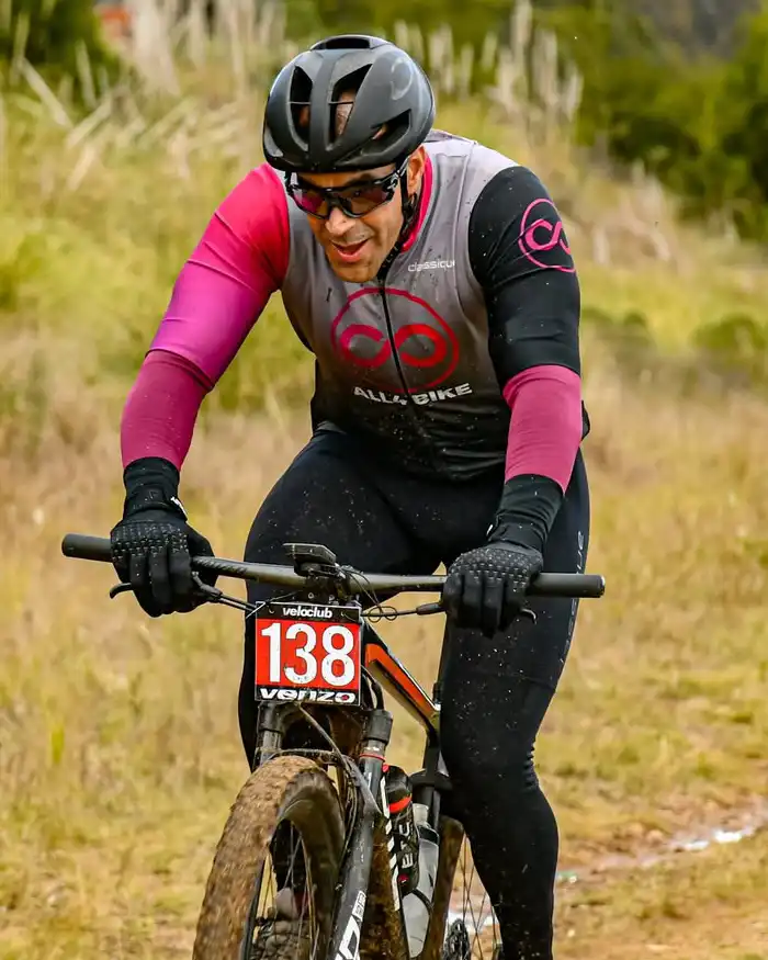 MTB en comunidades de Cusco: el rider lleva casco negro, gafas deportivas y guantes, manteniendo una postura agresiva para controlar el terreno.