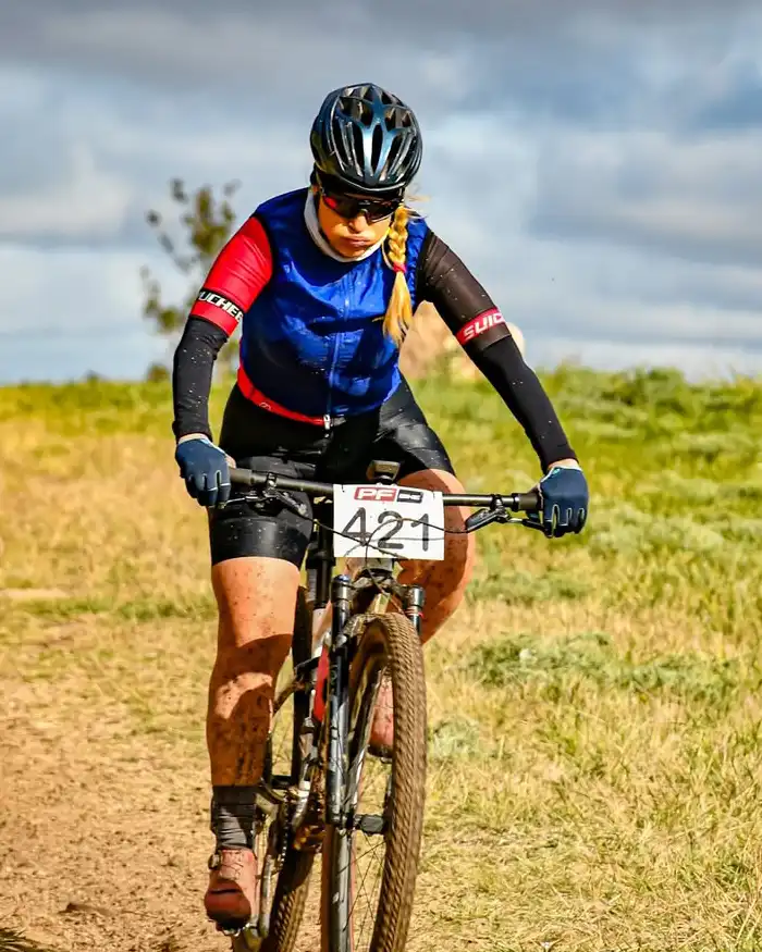 Lleva casco, gafas deportivas y guantes, con una postura inclinada hacia adelante que refleja concentración.