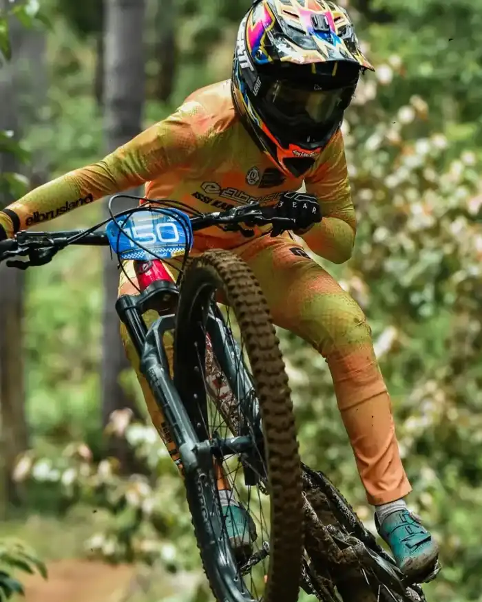 La bicicleta se encuentra ligeramente inclinada, mostrando control corporal y técnica durante el salto.