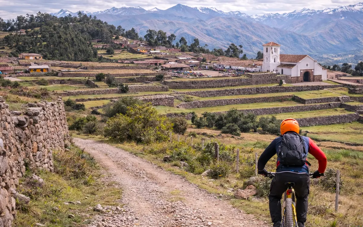 Un ciclista desciende por un camino rural de tierra y piedra en las afueras de Chinchero.