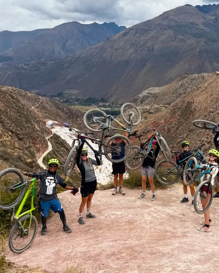 The Maras salt ponds can be seen in the distance, creating a striking white contrast against the mountainside.