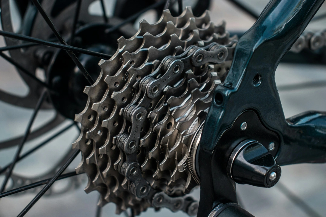 Close-up of a bicycle rear cassette and chain, showing the drivetrain gears and hub area in sharp detail.