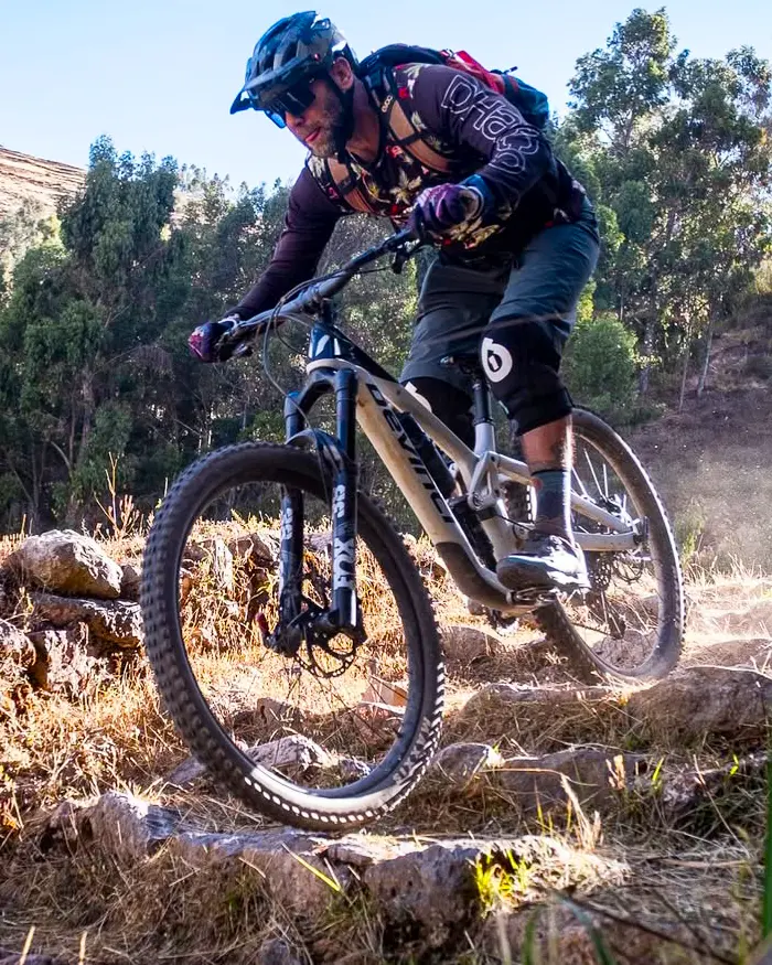 A cyclist descends with precision along a rocky trail, maintaining control in every movement.