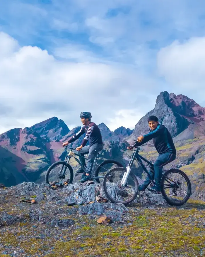 Both cyclists appear to pause to admire the landscape before continuing their route at high altitude.