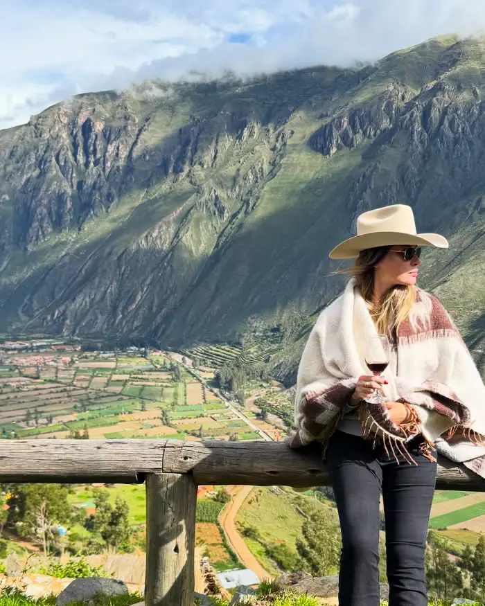 El paisaje andino se extiende al fondo con campos agrícolas que forman un mosaico de tonos verdes.