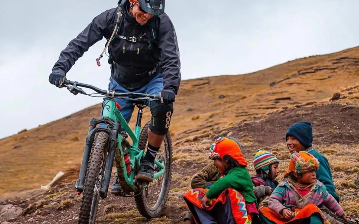 The image shows an authentic moment where MTB intersects with the everyday life of high Andean communities.