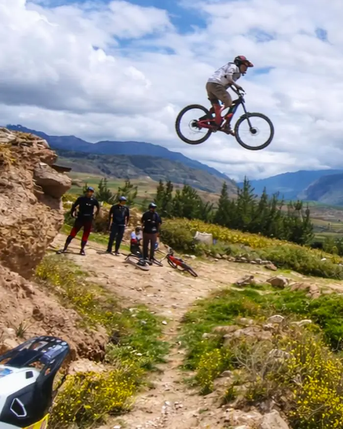 La escena captura el momento exacto en que la bicicleta queda suspendida, transmitiendo adrenalina y control en el Valle Sagrado.