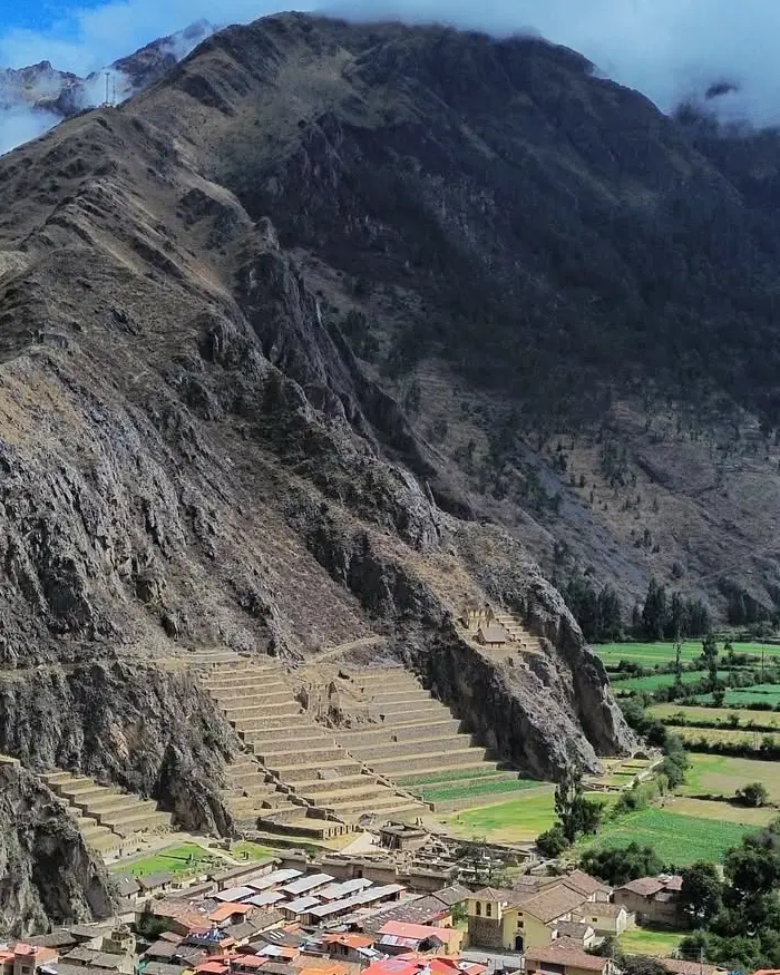 El pueblo se extiende al pie del valle con techos rojizos que contrastan con el verde de los campos cultivados.